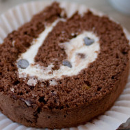 Rotolo al cacao con bagna al caffè, farcito con panna e gocce di cioccolato